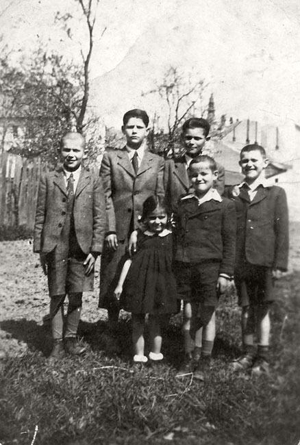 The Mandel family children in the yard of their home in Munkács in 1943, wearing their Sabbath clothes. Top row, left to right: Shmuel-Zvi (Sandor), David (Tibor), Yaacov-Moshe (Yeno Gino). Bottom row, left to right: Ester-Malkeh (Vera), Yehudah (Lajos) and Becalel Erno. The Mandel family children in the yard of their home in Munkács in 1943, wearing their Sabbath clothes. Top row, left to right: Shmuel-Zvi (Sandor), David (Tibor), Yaacov-Moshe (Yeno Gino). Bottom row, left to right: Ester-Malkeh (Vera), Yehudah (Lajos) and Becalel Erno.