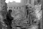 A Waffen SS soldier next to a destroyed house in the Warsaw Ghetto, 1943 A Waffen SS soldier next to a destroyed house in the Warsaw Ghetto, 1943