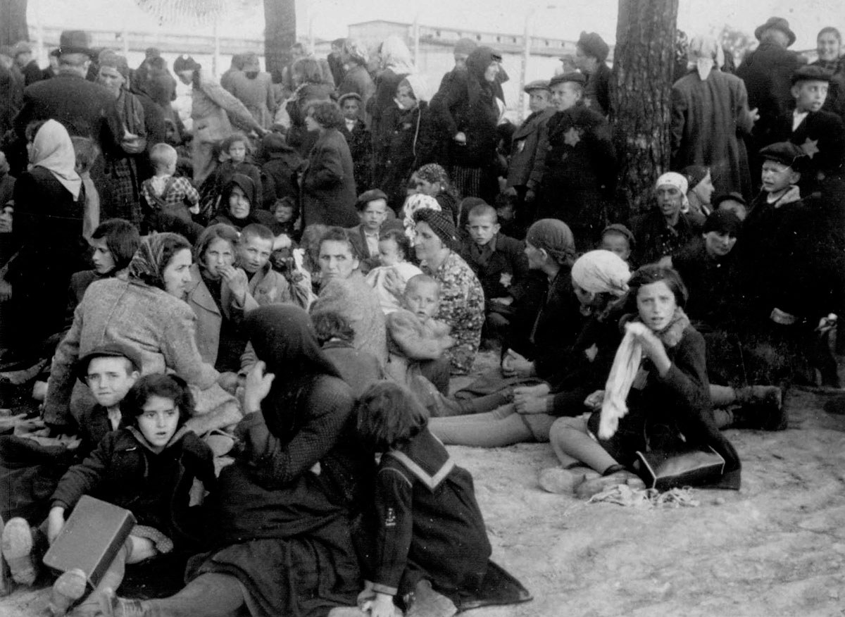 These were the last relatively peaceful moments together, before being driven into the gas chambers and murdered. In the background: the barracks of "Kanada"
