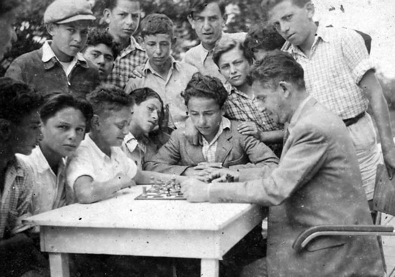 Children at the "Ilania" children's village playing chess with one of the counsellors.  Apeldoorn, the Netherlands, 1948