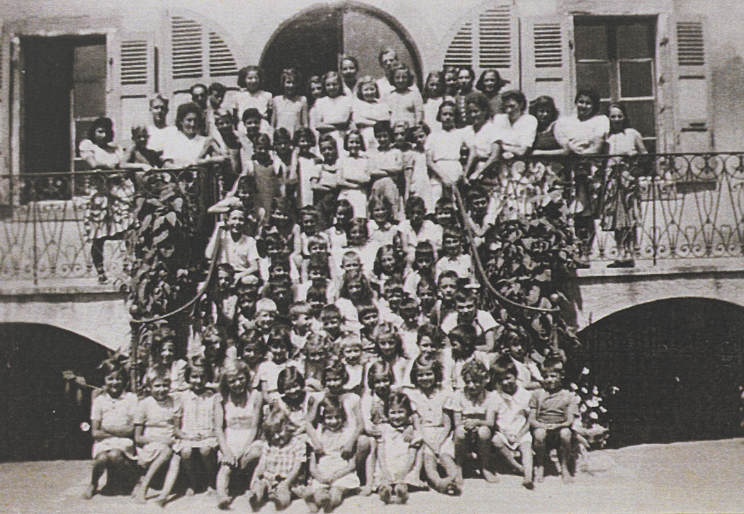 Photograph of all the children and staff (on the upper rows), at the children's home, on the same steps as the previous photo. Pringy, 1943
