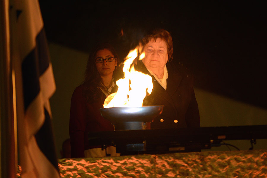 La sobreviviente del Holocausto Shela Altaraz encendiendo una de las seis antorchas durante la ceremonia