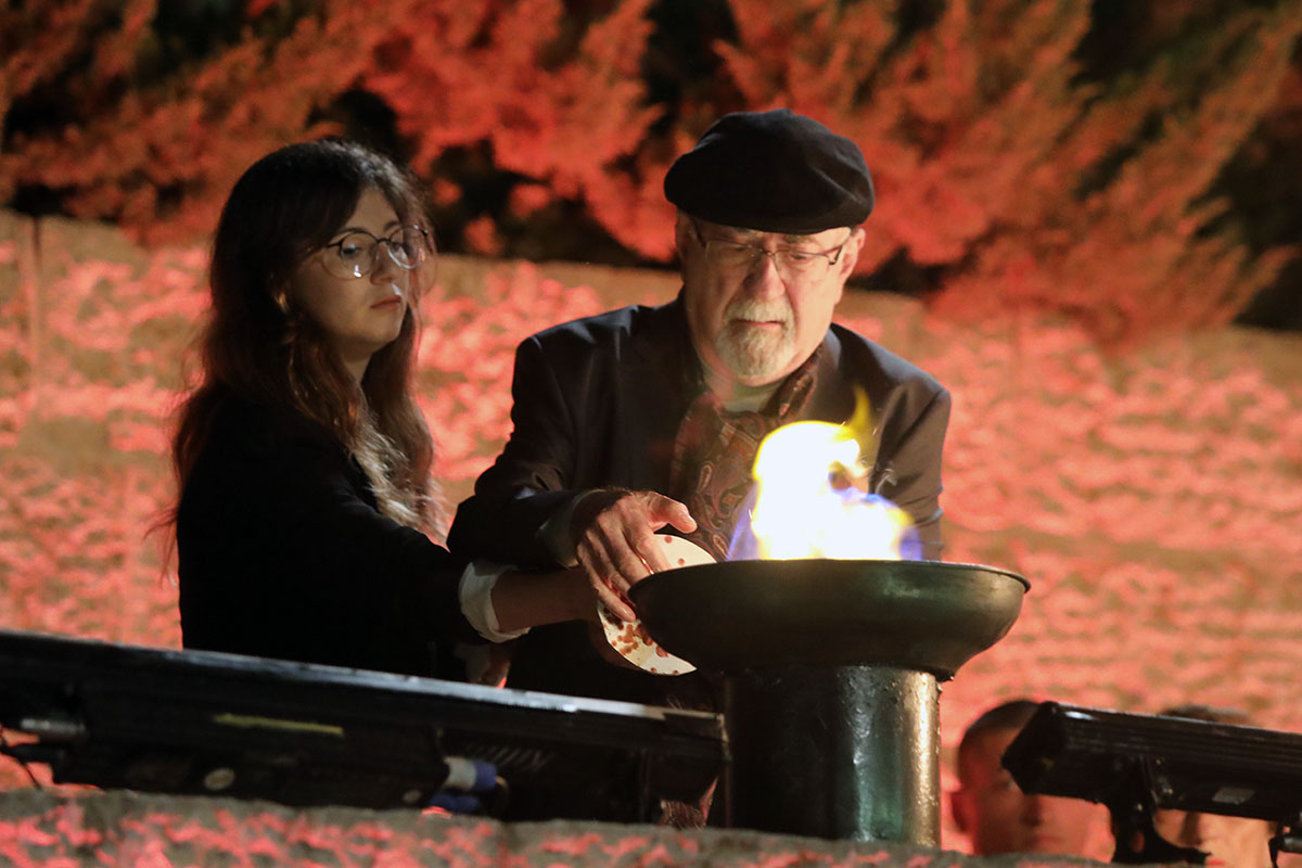 El sobreviviente del Holocausto Raul Teitelbaum encendiendo una de las seis antorchas durante la ceremonia