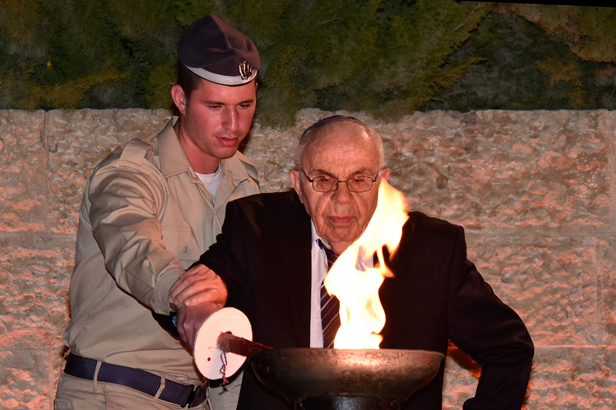 El sobreviviente del Holocausto Menachem Haberman encendiendo una de las seis antorchas durante la ceremonia