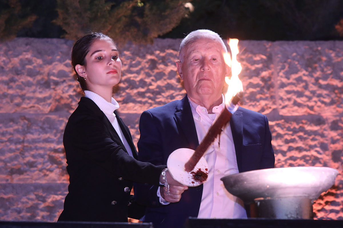 El sobreviviente del Holocausto Shaul Lubovitz encendiendo una de las seis antorchas durante la ceremonia