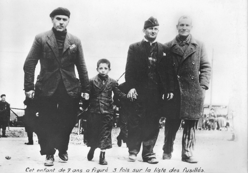 Un enfant encadré par des résistants de Buchenwald, à la libération du camp. Buchenwald, Allemagne, juin 1945