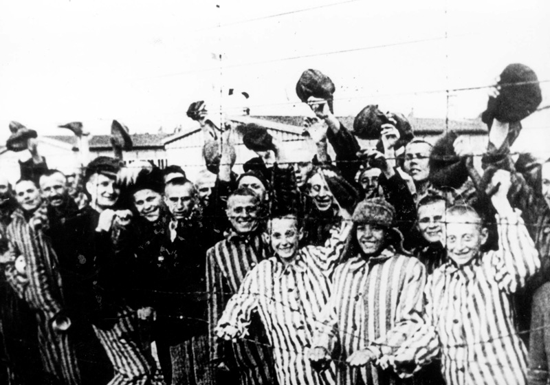 Des enfants, survivants de Buchenwald, derrière des barbelés, à la libération du camp. Buchenwald, Allemagne, 1945