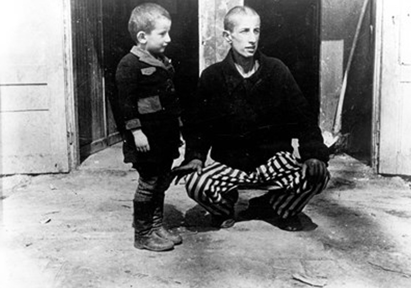 Un des benjamins de Buchenwald, âgé de 4 ans à la libération du camp, aux côtés d'un autre rescapé de 15 ans, au moment de la libération. Buchenwald, Allemagne, 1945 
