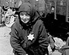 Аушвиц-Биркенау, Польша. Пожилая женщина с желтой звездой на одежде стоит на платформе.